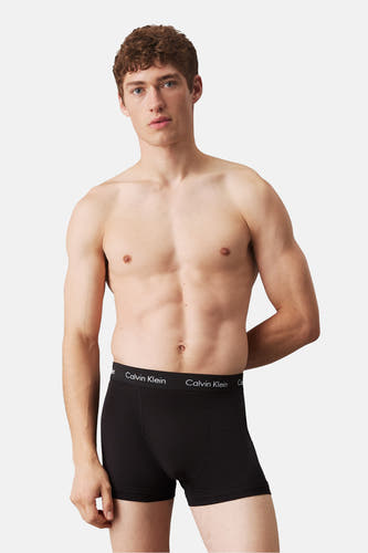 Short de boxers Calvin Calvin Klein, port par un model modèle avec le corps nu et les mains derrière le dos.