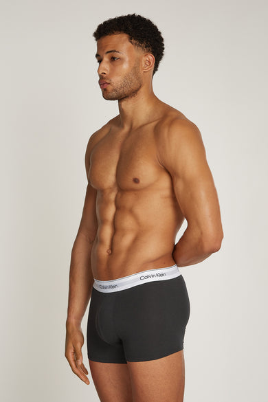 Homme en short de boxeur Calvin Klein gris, debout.