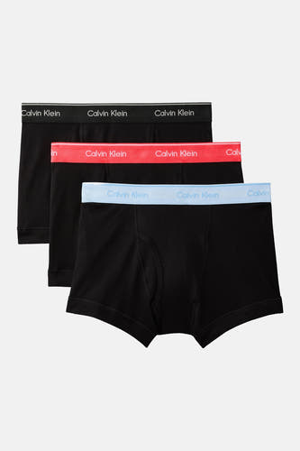 Boxer noir Calvin Klein, gros plan de profil avec ceinture rouge et un homme qui joint ses mains.