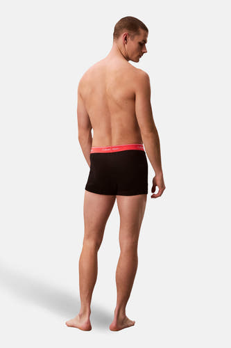 Zwarte boxershort van Calvin Klein, rugaanzicht met rode tailleband en merklogo.
