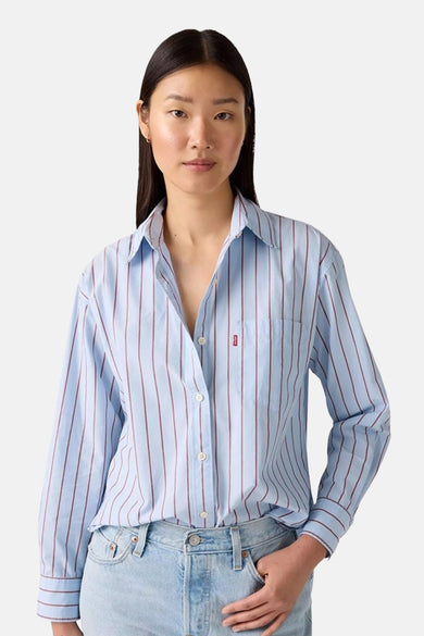 Chemise rayée bleue de Levi's à longues manches, avec une poche et des jeans bleus clairs.