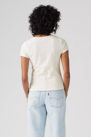 Een vrouw van achteren, met een beige shirt en een lichte blauwe jeans.