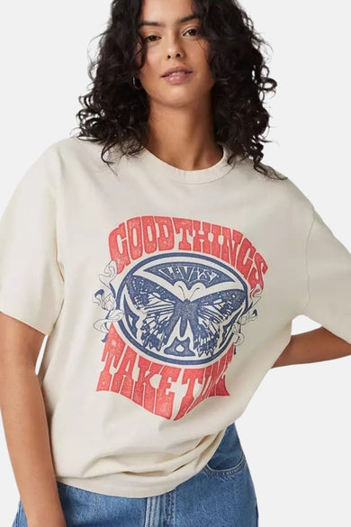 T-shirt écru à manches courtes avec imprimé rouge et bleu de Levi's®, porté par un mannequin aux cheveux bouclés, photo lifestyle