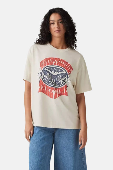 T-shirt écru à manches courtes de Levi's® avec imprimé papillon rouge et bleu, porté par un mannequin dans une photo lifestyle