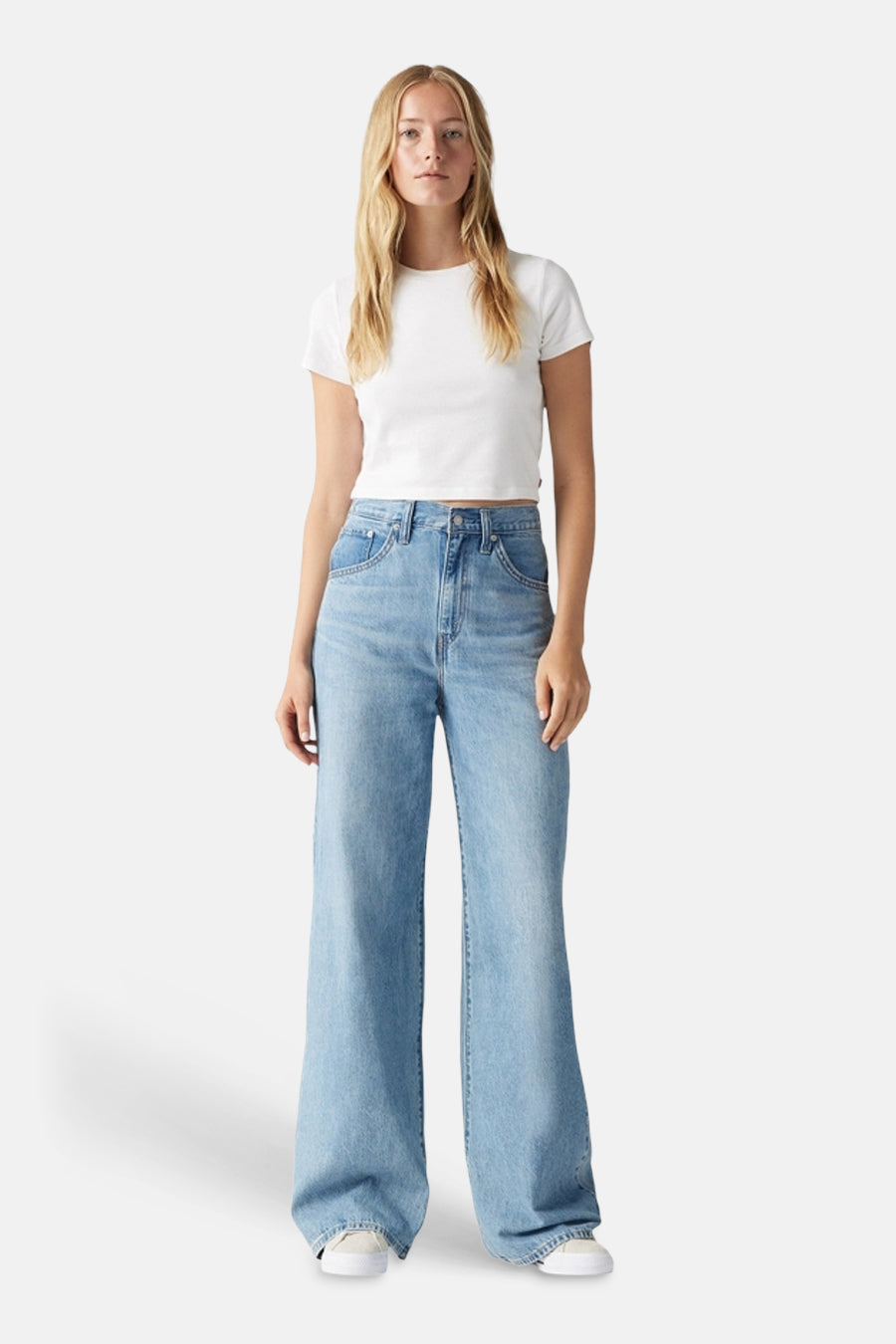 Jean large bleu clair en denim de Levi's, avec un t-shirt blanc et des chaussures blanches.