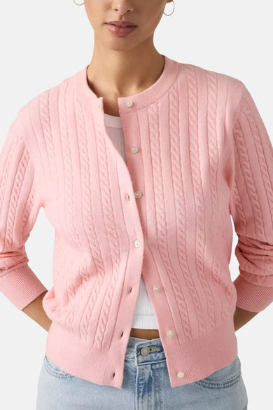 Gilet rose de Levi's, avec motif côtelé, longues manches et porté sur un haut blanc et un jean.