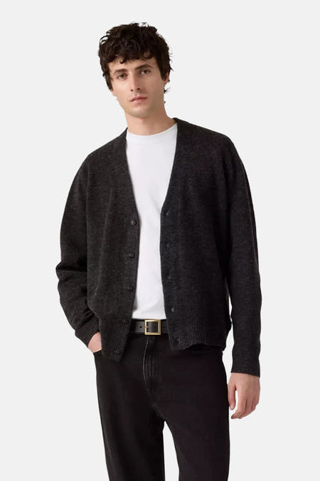 Veste grise de Levi's®, portée ouverte sur un t-shirt blanc, avec des jeans noirs et une ceinture.