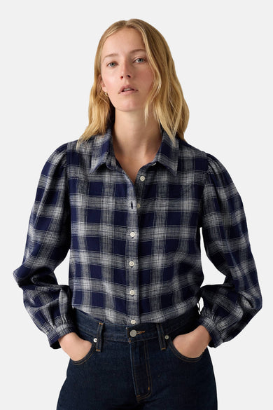 Chemise bleue à manches longues de Levi's®, rayée et avec des poignets, associée à un jeans bleu marine.