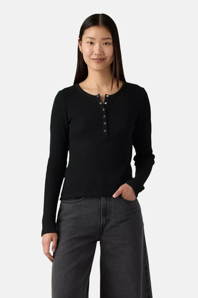 T-shirt noir à manches longues de Levi's, avec une fermeture à boutons et une texture côtelée, associé à un jean gris.