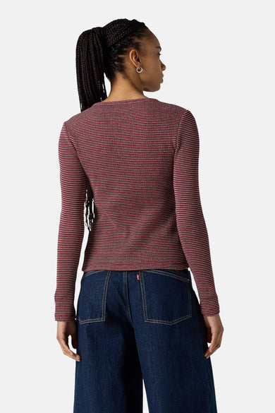 T-shirt rouge vin de Levi's à manches longues, avec un motif fin et géométrique à points, porté avec un jeans bleu foncé.