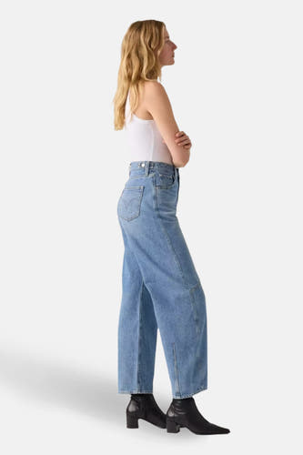 Jean spécial fit en denim bleu clair de Levi's, avec des jambes larges et porté avec un haut blanc et des chaussures noires.