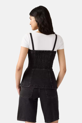 Jean noir de Levi's®, porté sur un t-shirt blanc, avec des épaulettes et un short.