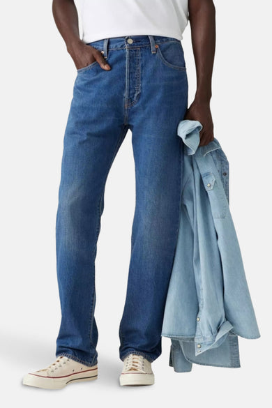 Jean droit en denim bleu moyen de Levi's, avec fermeture à boutons et style classique cinq poches.