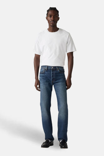 Jean de denim bleu foncé de Levi's, porté avec un T-shirt blanc et des chaussures noires.