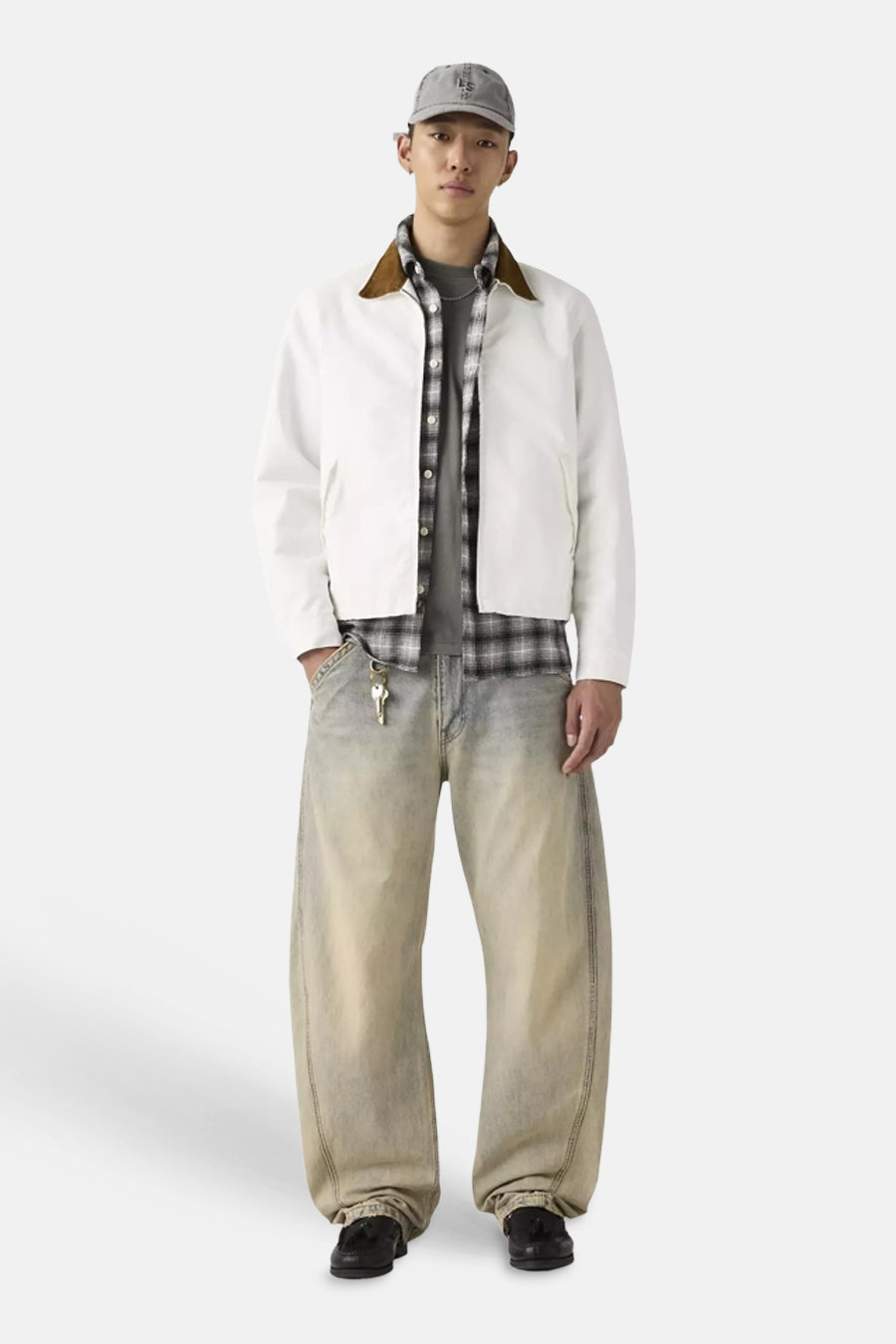 Jeans larges Levi's® en denim délavé bleu clair avec une coupe spéciale, portées avec une veste blanche et une chemise à carreaux.