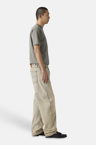 Jean coupe spéciale en denim bleu clair de Levi's® à jambes larges, porté par un homme de profil avec un t-shirt gris et des mocassins noirs.