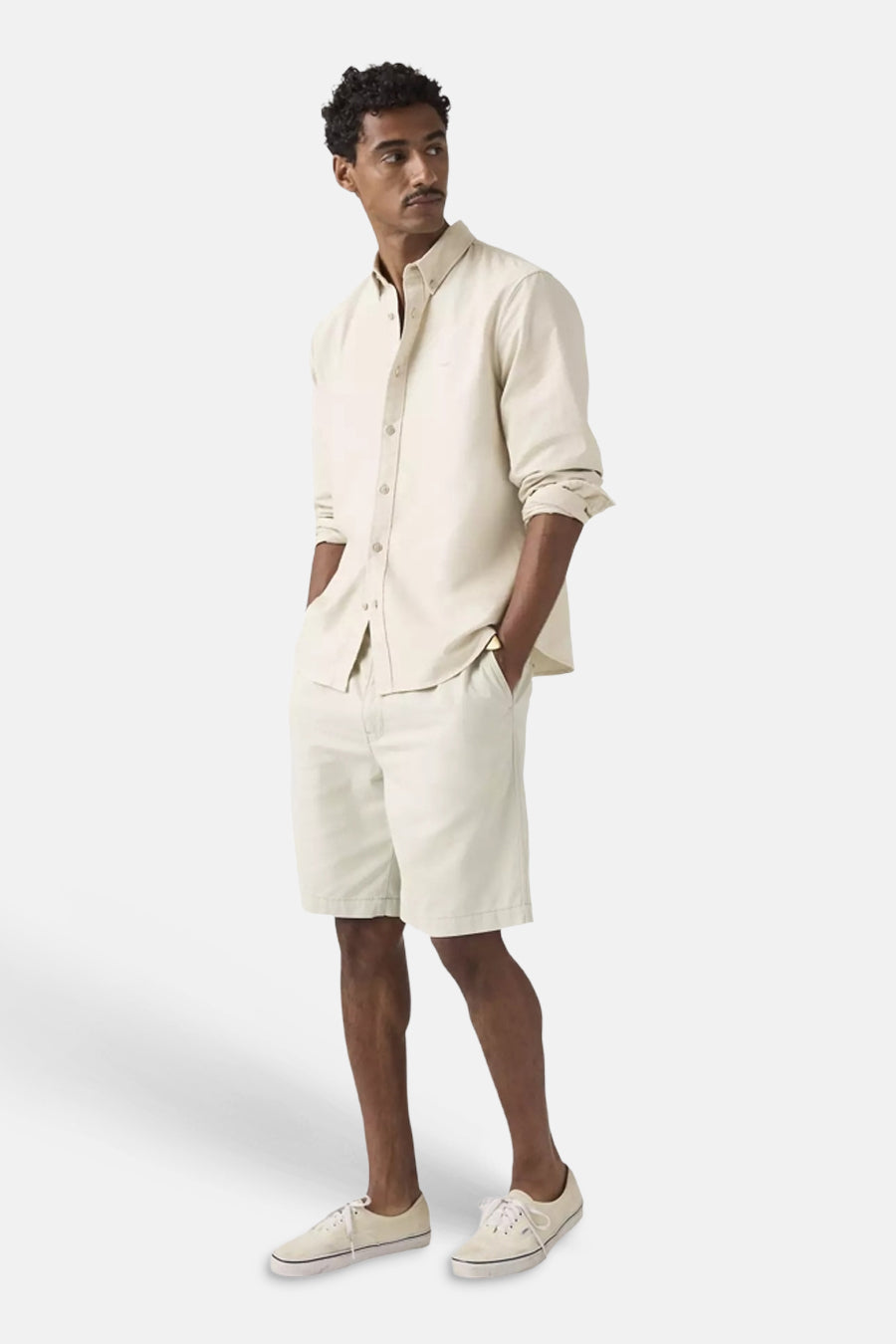 Short de couleur écru de Levi's® portée par un homme, associée à une chemise écrue et des baskets de couleur crème.