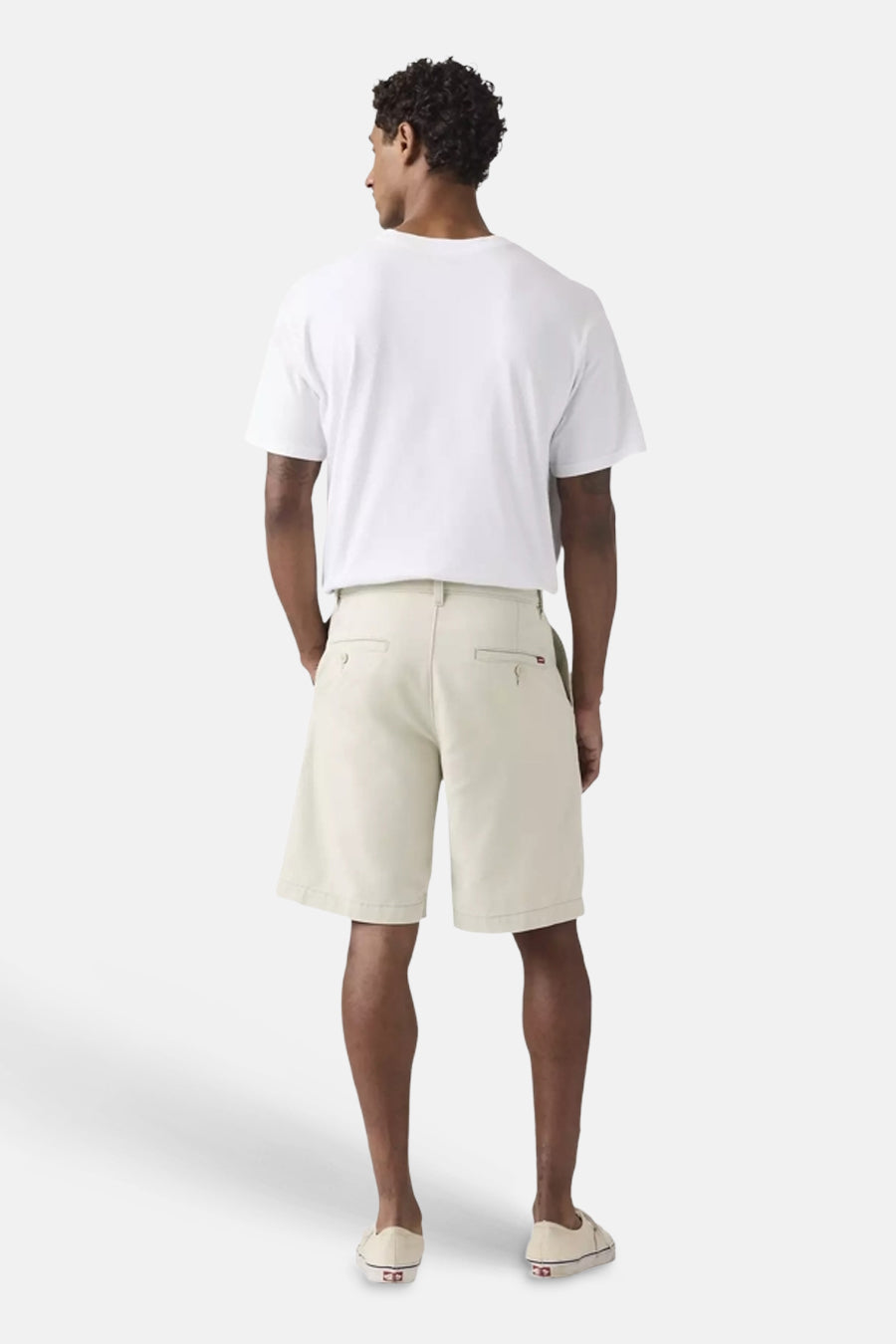 Ecru shorts van Levi's®, achterkant zichtbaar op een man met wit T-shirt en lichte instapschoenen.