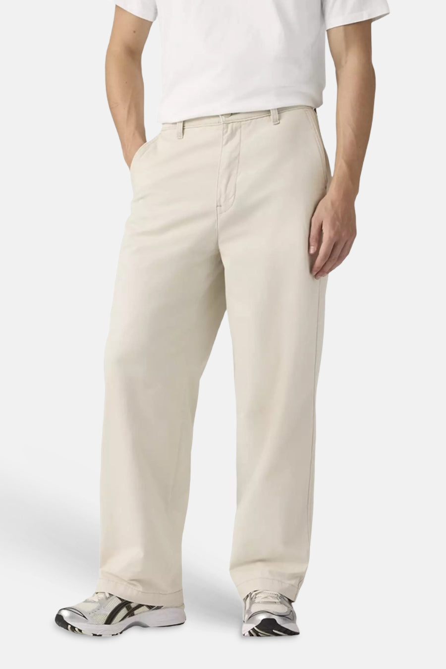 Chino beige de Levi's® avec coupe décontractée et étiquette rouge, porté par un homme avec un t-shirt blanc, de profil.
