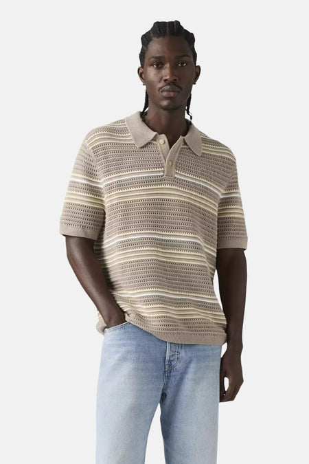 Polo beige à rayures de Levi's® avec texture ajourée, portée avec un jean bleu clair.