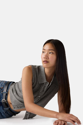 Haut grise sans manches de Levi's, avec fermeture à boutons et portée avec un jean bleu et une ceinture noire.