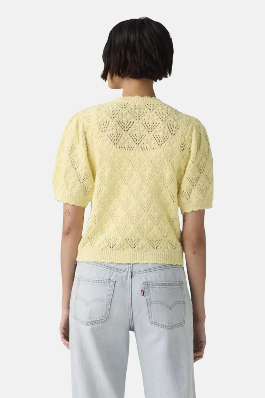 Gele gebreide gilet met geometrisch patroon van Levi's®, achterkant weergegeven, korte mouwen, lichte textuur, model draagt lichte jeans