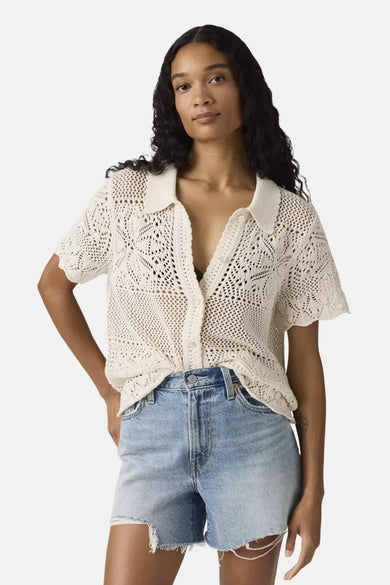 Chemise blanche à manches courtes de Levi's®, avec motif ajouré et portée avec un short en jean.