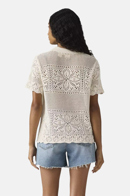 Chemise blanche à manches courtes de Levi's®, avec un motif ajouré et portée avec un short en jean.