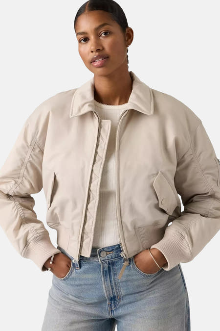 Veste courte grise de Levi's, à manches longues et portée sur un jean bleu.
