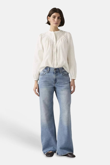 Jean bootcut bleu clair en denim de Levi's, taille haute et évasé, porté par un mannequin.