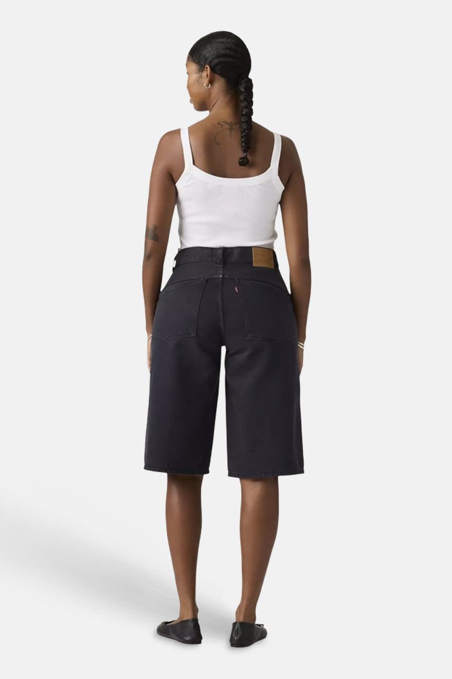 Short noir Levi's® avec patch en cuir et languette rouge sur la poche arrière, vue arrière du mannequin en débardeur blanc.