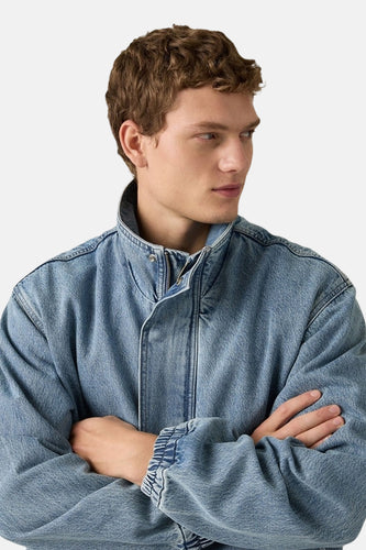 Korte denim jas van Levi's, met opstaande kraag en gekruiste armen.
