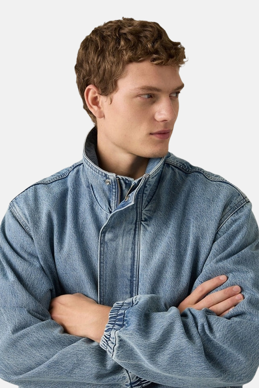 Korte denim jas van Levi's, met opstaande kraag en gekruiste armen.
