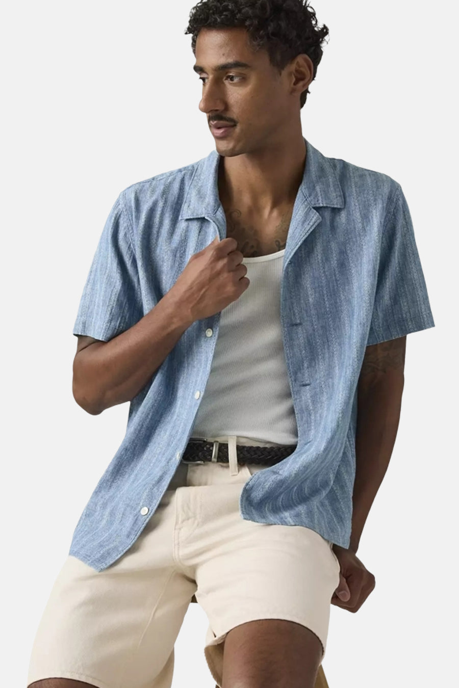Chemise bleu clair à manches courtes de Levi's®, avec une fine structure côtelée, un col ouvert et portée sur une chemise blanche.