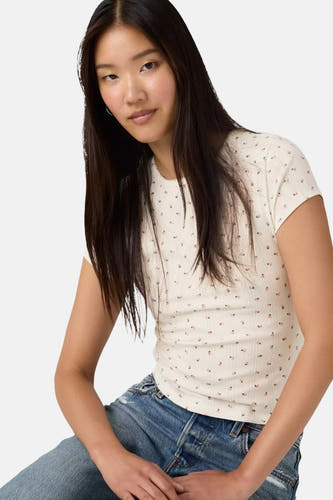 T-shirt blanc à manches courtes de Levi's®, avec une impression de petites fleurs et une structure en côtes verticales, porté avec un jean bleu.