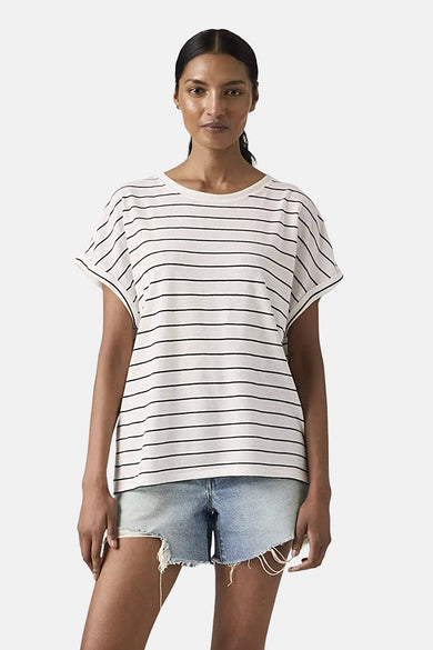 T-shirt blanc à rayures de Levi's, porté avec une ceinture noire et un short en jean.