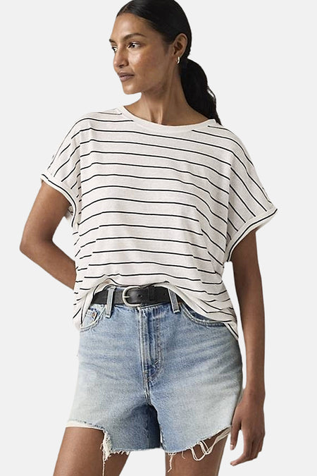 Wit gestreept T-shirt van Levi's, gedragen met een zwarte riem en denim shorts.
