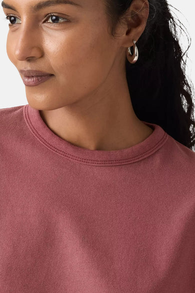 T-shirt Levi's à manches courtes rose, gros plan avec une femme portant des boucles d'oreilles en argent.