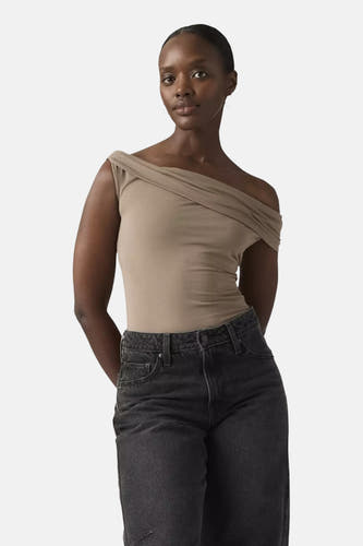 Haut beige de Levi's® avec un col bardot drapé, porté par un mannequin dans un jean foncé.