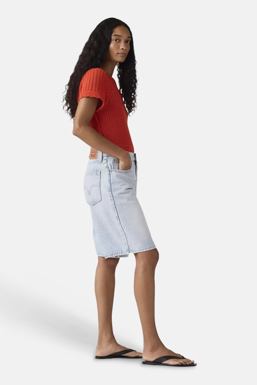 Short en jean bleu clair de Levi's® longueur genou, vue de profil avec les mains dans les poches.