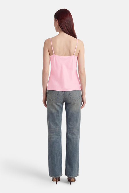 Roze top van Terra di Siena met spaghettibandjes, van achteren gezien, gedragen met jeans en hakken.