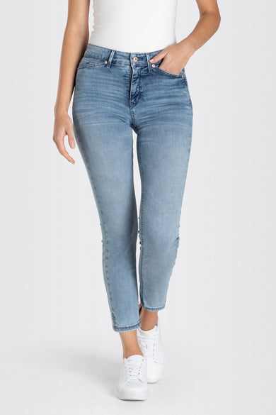 Jean droit bleu moyen de MAC, denim légèrement délavé avec de subtiles ondulations, coupé pour une coupe moderne, porté avec des baskets blanches.