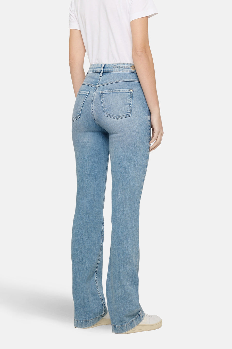 Lichtblauwe bootcut jeans van MAC, met achterzakken en gedragen met een wit T-shirt.
