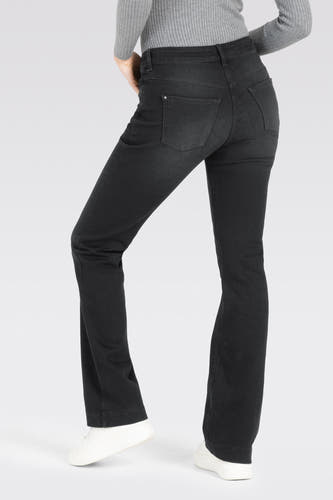 Donkergrijze bootcut jeans van MAC, met achterzakken, gecombineerd met een grijze top en witte sneakers.
