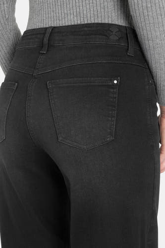 Jean délavé noir de MAC, avec des poches arrière et des passants, porté avec un pull gris.