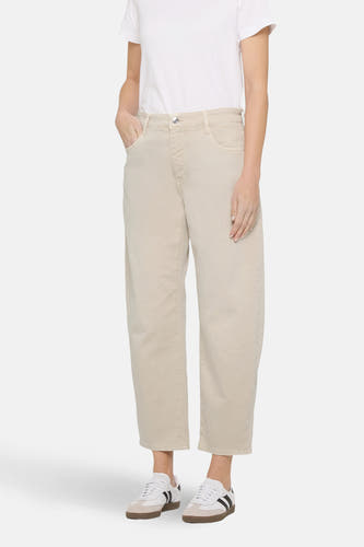 Jean délavé blanc de MAC, avec une coupe décontractée et associé à un T-shirt blanc et des baskets.