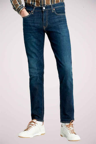 Donkerblauwe slim fit jeans van Levi's, met een klassieke vijf-pocket styling en witte sneakers.