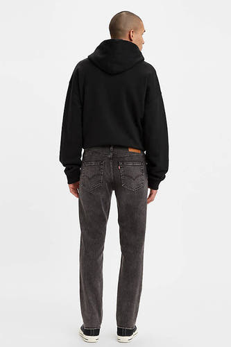 Donkergrijze slim-fit jeans van Levi's®, achterzijde met dubbele achterzakken en rits, gedragen met zwarte hoodie en sneakers