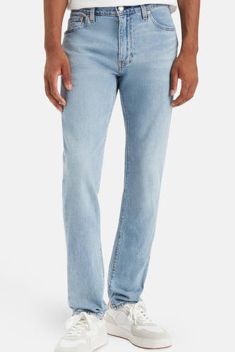 Jean slim de denim bleu clair de Levi's®, porté avec des baskets blanches.