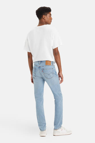 Jean slim fit en denim bleu clair de Levi's, avec un t-shirt blanc et des chaussures blanches.